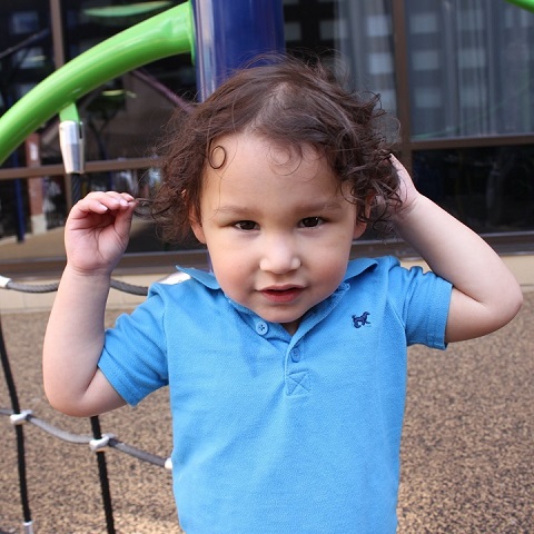 shy toddler boy in blue shirt