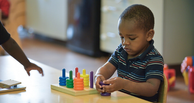 preschool boy playing with colorful pegs